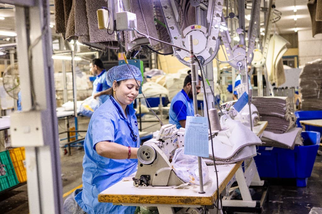 Operadora trabalhando em uma máquina de costura industrial